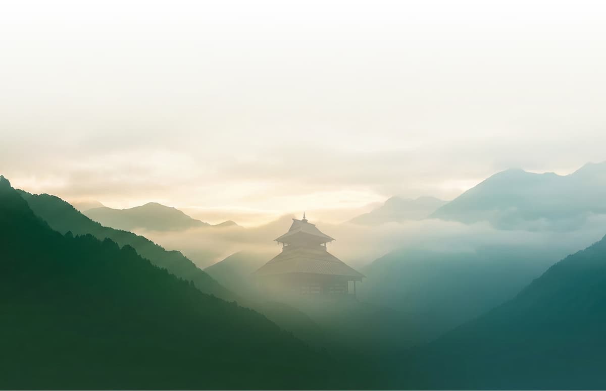Traditional wooden pagoda temple amid misty Himalayan mountains